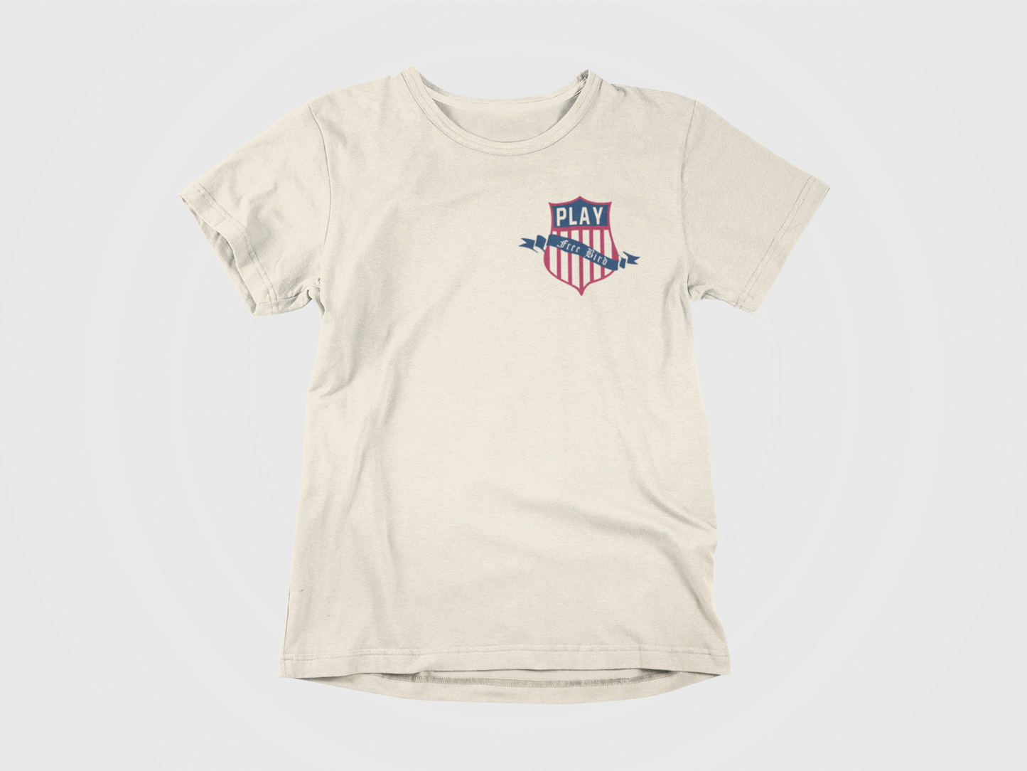 Front of Shirt, Cream colored, Says Play Free Bird over the USA Hockey Crest with an American Eagle