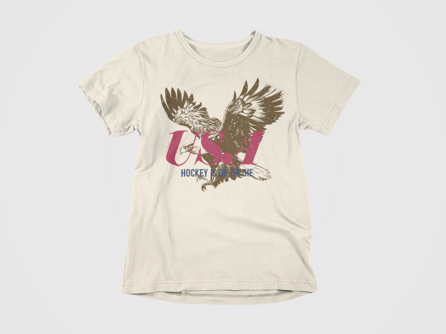 Front of shirt, cream colored shirt, Brown Bald Eagle with Red USA and in Blue says Hockey is Do or Die, USA Hockey